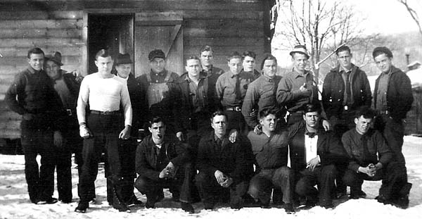 Group of camp members in front of barracks
